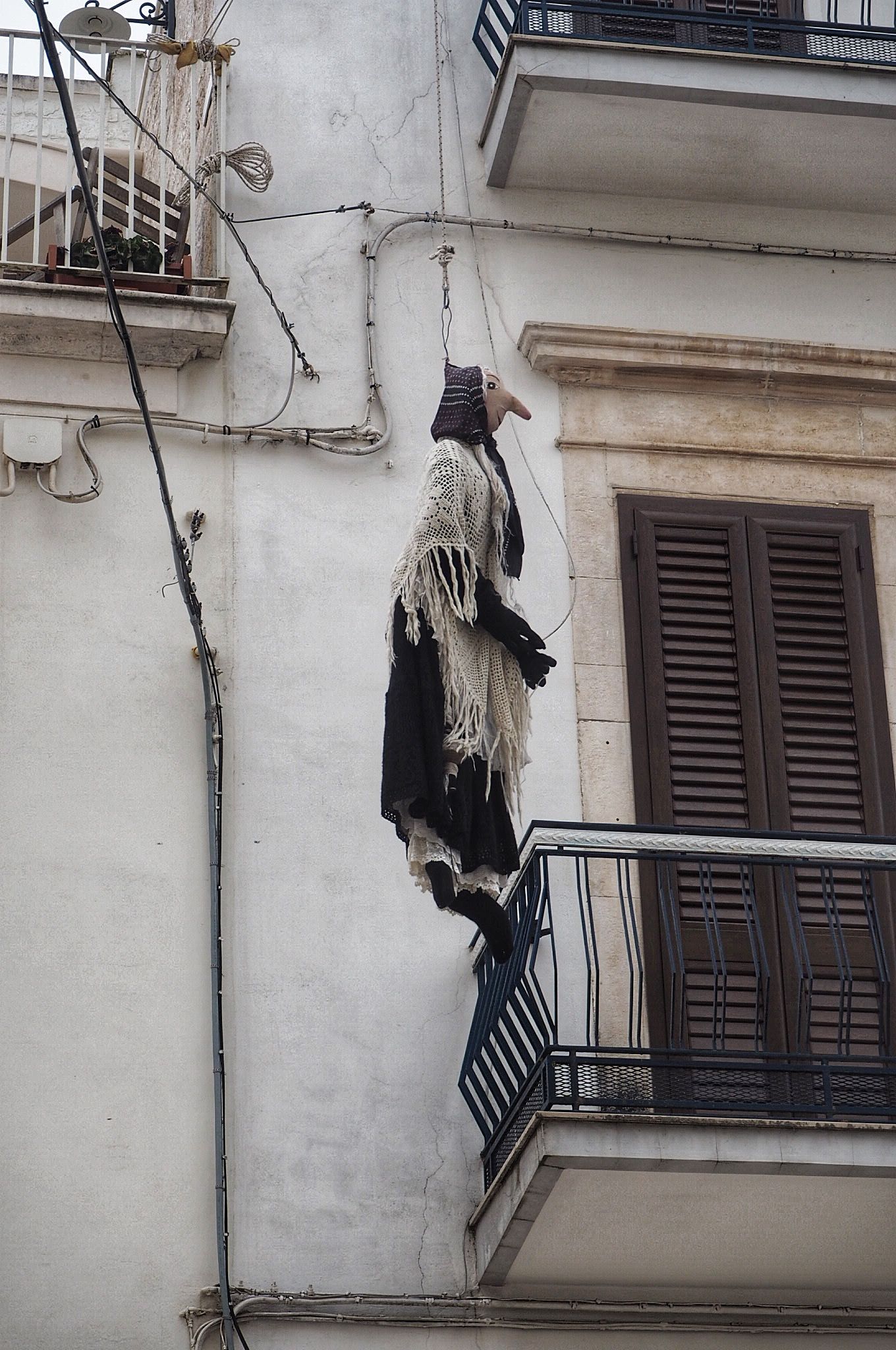 Puglia Quarandone puppets hanging from rope in the street