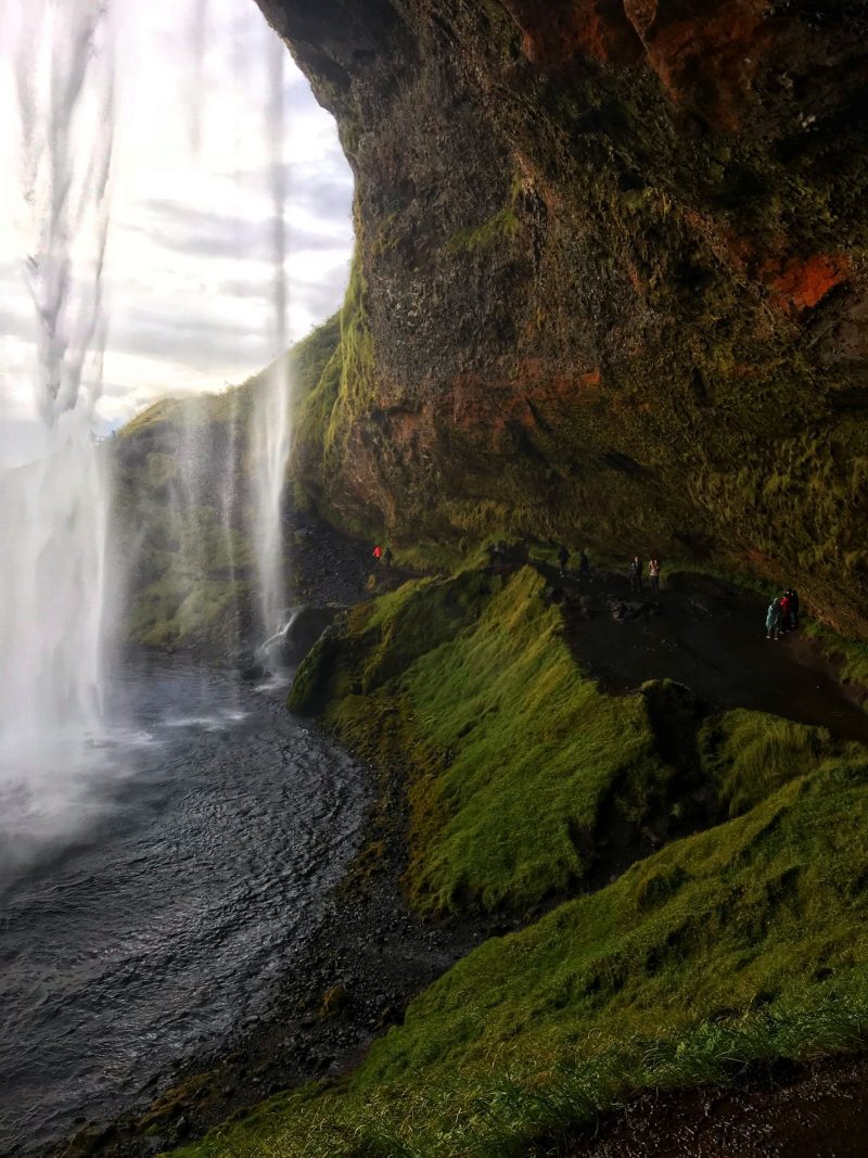 Autumn hues walking behind Seljalandsfoss Waterfall Southern Iceland